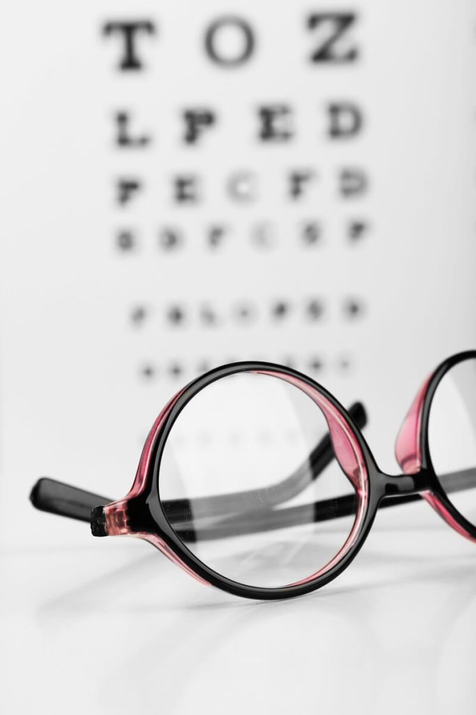 Lunettes posées devant un tableau d’acuité visuelle flou